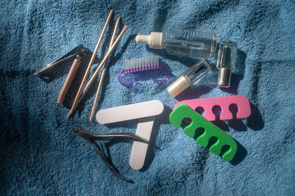 manicure file set with glass, crystal, and emery board files laid out on a white marble surface